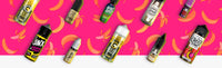 Assorted colorful e-liquid bottles on a vibrant pink and banana-themed background, featuring various flavors and brands.