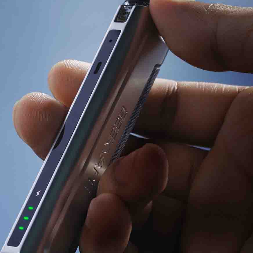Person holding a sleek smartphone showing LED indicators on the side under gentle lighting.