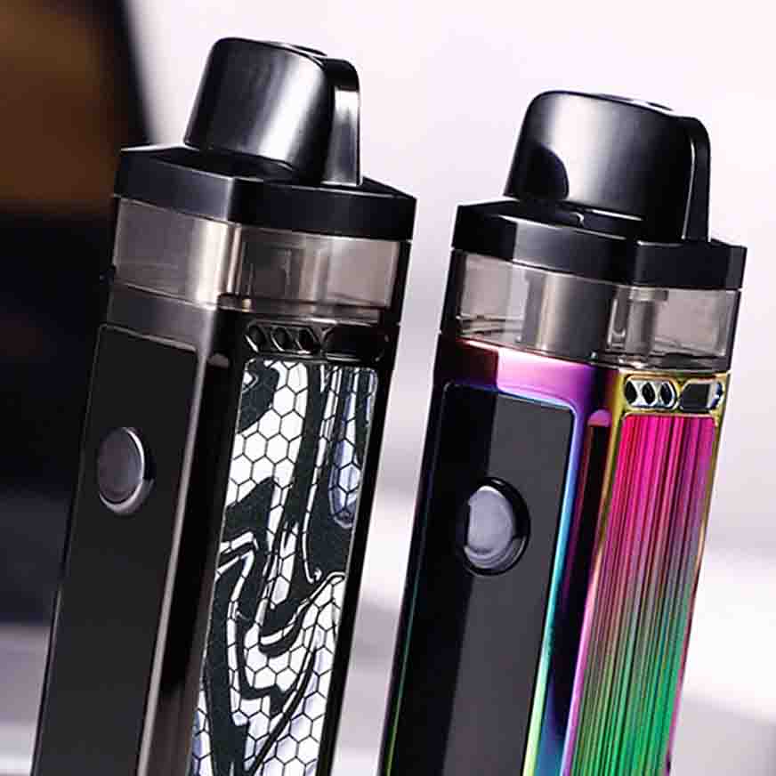 Two sleek vape devices with colorful designs, one black and silver with a pattern, and the other with a rainbow finish on a reflective surface.