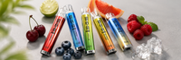 Five SKE Crystal Bar 600 prefilled pod kits in different flavour colours arranged with fresh fruit on a light grey studio background.